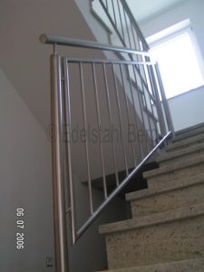 Treppengeländer aus Edelstahl im Treppenhaus in der Ausführung „Standard plus“: Pfosten und Handlauf aus Edelstahlrohr mit 42,4 mm Durchmesser, Füllung aus senkrechten Stäben Durchmesser 12 mm aus Edelstahl. Rimbach, Weschnitztal, Kreis Bergstraße