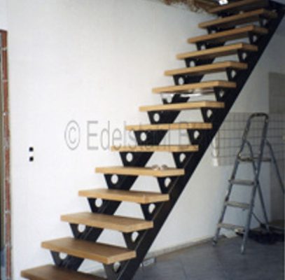 Innentreppe aus Edelstahl-Rechteckrohr mit aufgeschweißten Stufenblechen, hier mit einem Kreisausschnitt, mit denen die Holzstufen verschraubt werden