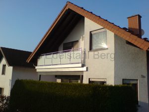 Balkongeländer aus Edelstahl mit Füllung aus Milchglas ( VSG - Verbundsicherheitsglas mit weißer Folie), Befestigung von oben, mit Blechverkleidung an der Stirnseite des Balkones. Gauangelloch, Rhein-Neckar-Kreis