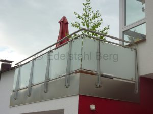 Balkongeländer aus Edelstahl mit Füllung aus Milchglas (VSG – Verbundsicherheitsglas mit weißer Folie). Besonders extravagant: Die Pfosten sind hier nicht aus Edelstahlrohren sondern aus 5 mm dickem Blech geschnitten. Die Umrandung des Garagendaches wurde zuvor mit Edelstahlblech abgedeckt und verschweißt. Fürth, Odenwald, Kreis Bergstraße