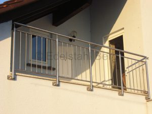 Balkongeländer aus Edelstahl „Standard“-Ausführung: Pfosten und Handlauf aus Edelstahlrohr mit 42,4 mm Durchmesser, waagrecht verlaufende Ober- und Untergurte aus 26,9 mm Edelstahlrohr, Füllung aus senkrechten Edelstahlstäben (Durchmesser 12 mm), hier Befestigung von vorne. Spechbach, Rhein-Neckar-Kreis, Baden-Württemberg