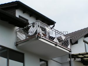 Balkongeländer aus Edelstahl-Rundrohr mit Fischgrätenmuster aus 12 mm Edelstahlstäben und mit Motivblechen aus Edelstahlblech. Fürth, Odenwald, Kreis Bergstraße
